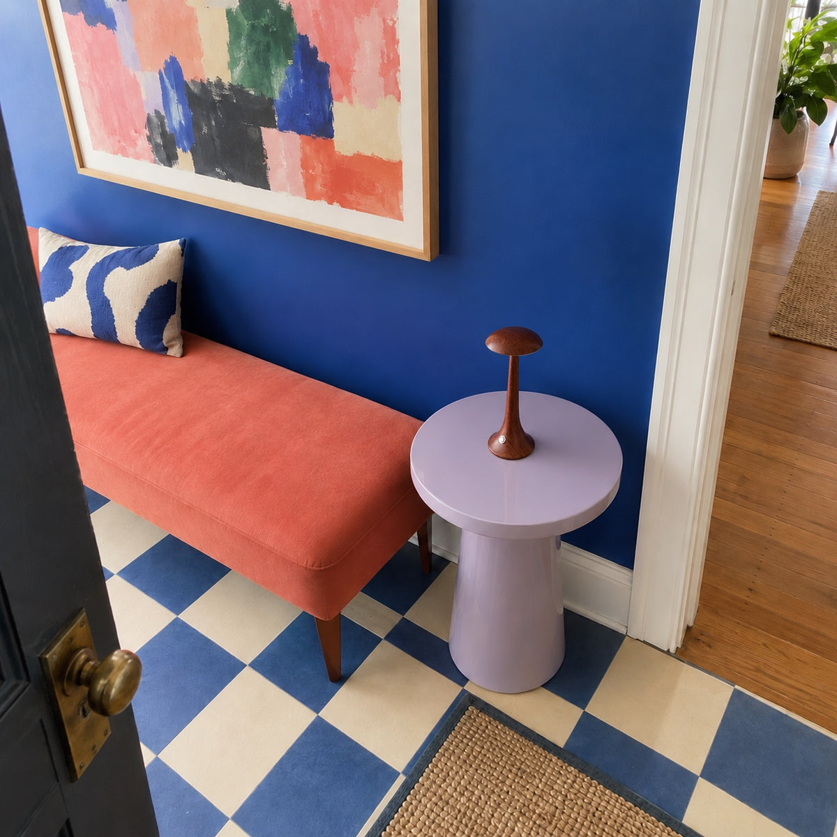 Lampe Morel sur un guéridon lilas, entrée au sol en damier bleu