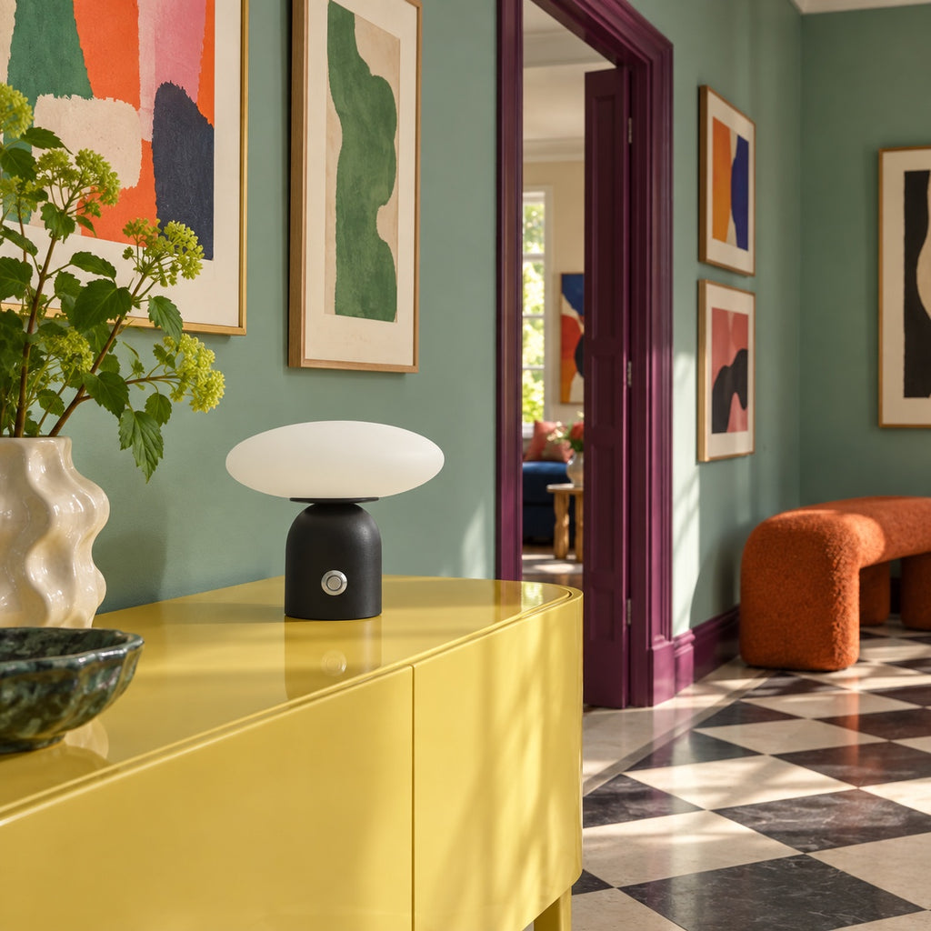Lampe Pebble sur une console jaune, entrée aux murs verts
