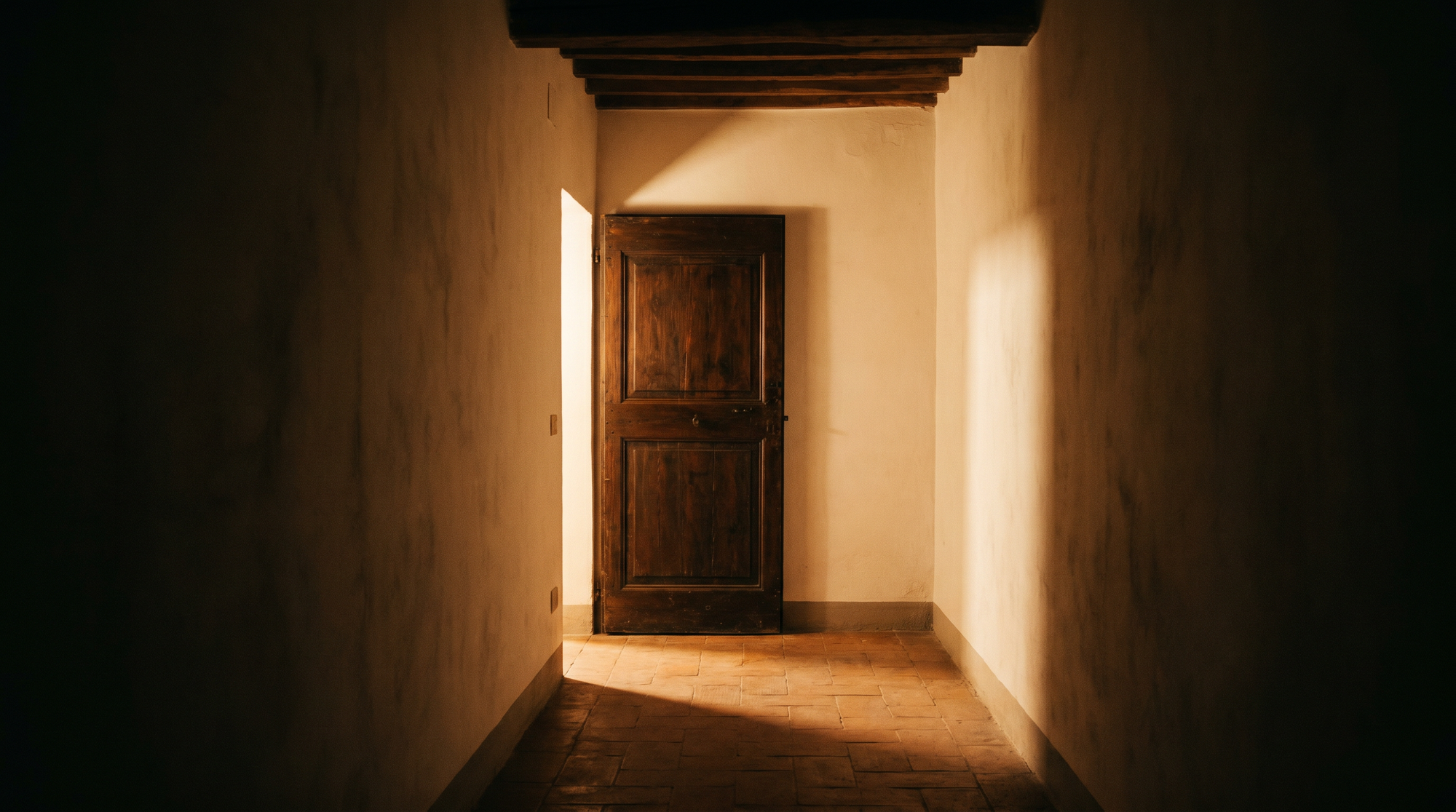 Porte en bois entrouverte dans un couloir sombre, lumière chaude qui s’en échappe