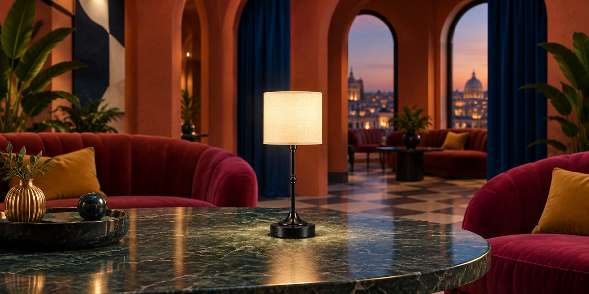 Lampe Mayfair noire allumée sur une table en marbre vert, salon rouge le soir