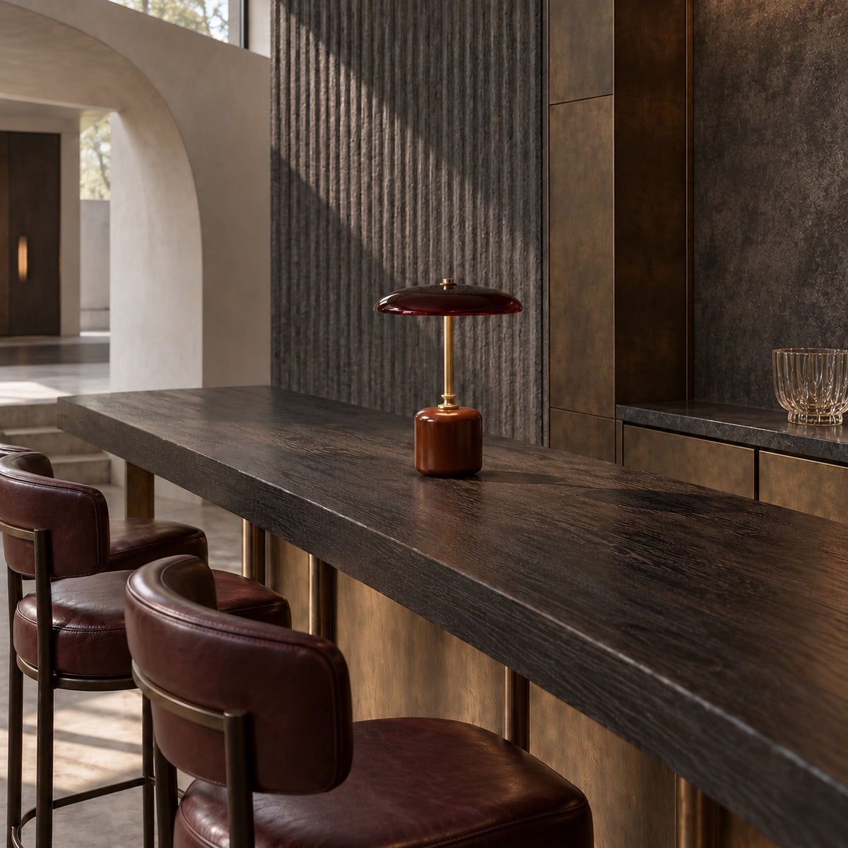Lampe Merlot sur un comptoir en bois sombre, bar aux tabourets en cuir