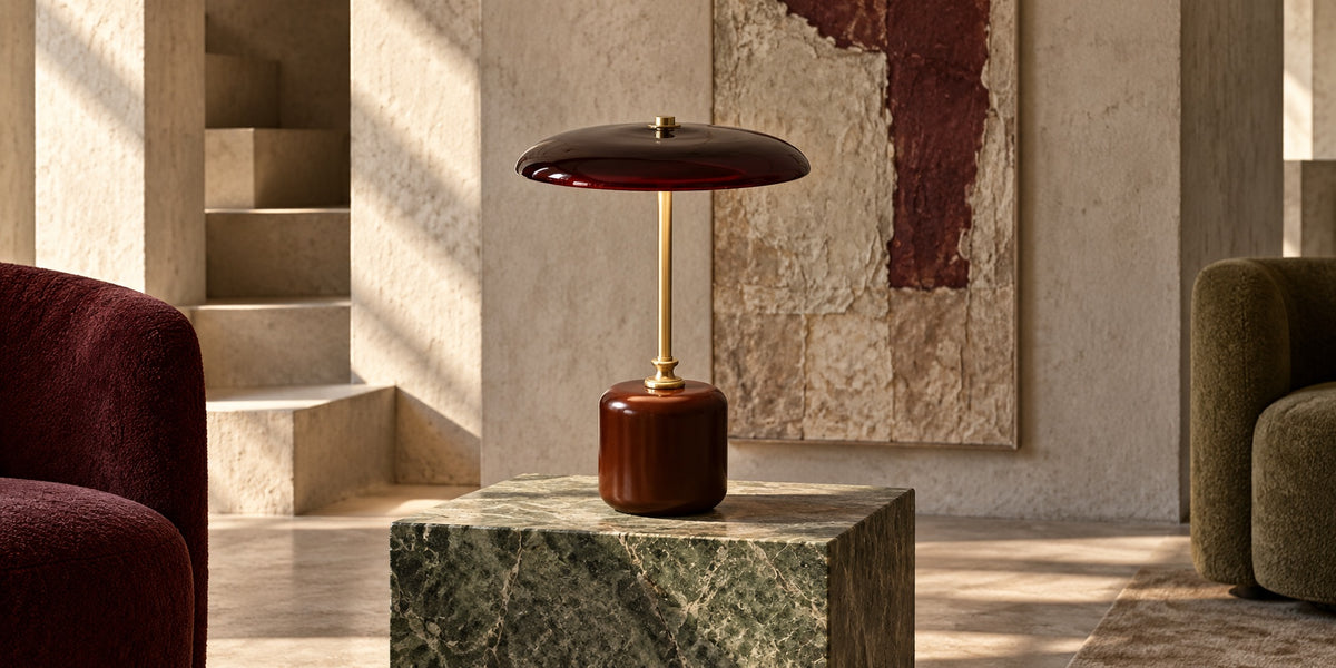 Lampe Merlot sur un cube de marbre vert, salon aux tons sable