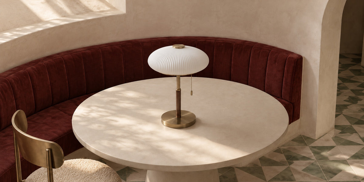 Lampe Oslo sur une table ronde, banquette en velours bordeaux
